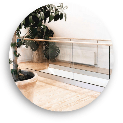 Dachgeschoss mit Glasgeländer, Holzhandlauf und Klemmbefestigung. Das transparente Glas kombiniert mit warmen Holzelementen ergibt eine sichere und luftige Abgrenzung des Wohnraums.