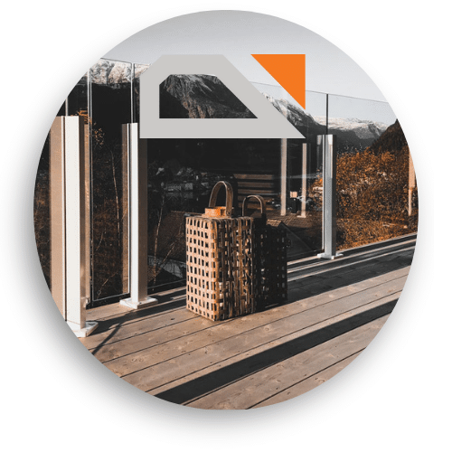 Glasgeländer mit weißen Pfosten und Klemmen – Ausblick über Berge von Holzterrasse mit zwei Laternen.